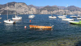 Saill boats with their sails furled and small motor boats moored on Lake Garda Italy